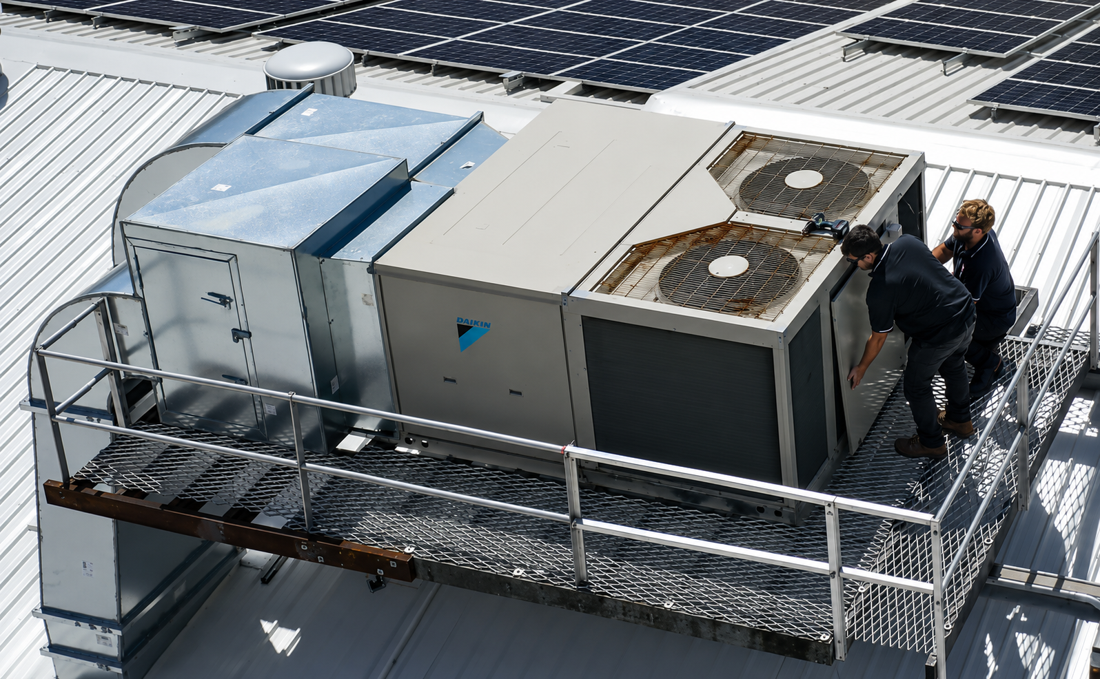 A coastal rooftop Daikin packaged air conditioning unit being serviced by SETPOINT technicians, with rust forming on the fan grilles