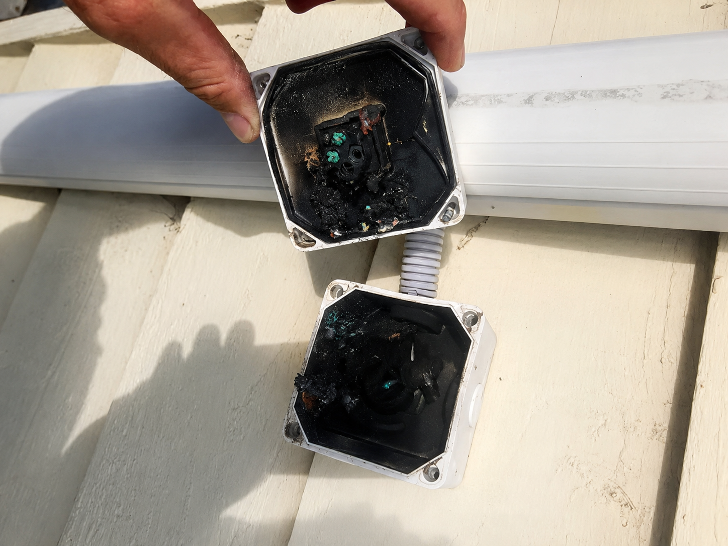 Burnt-out, melted air conditioner junction boxes found on inspection — an electrical fault waiting to happen