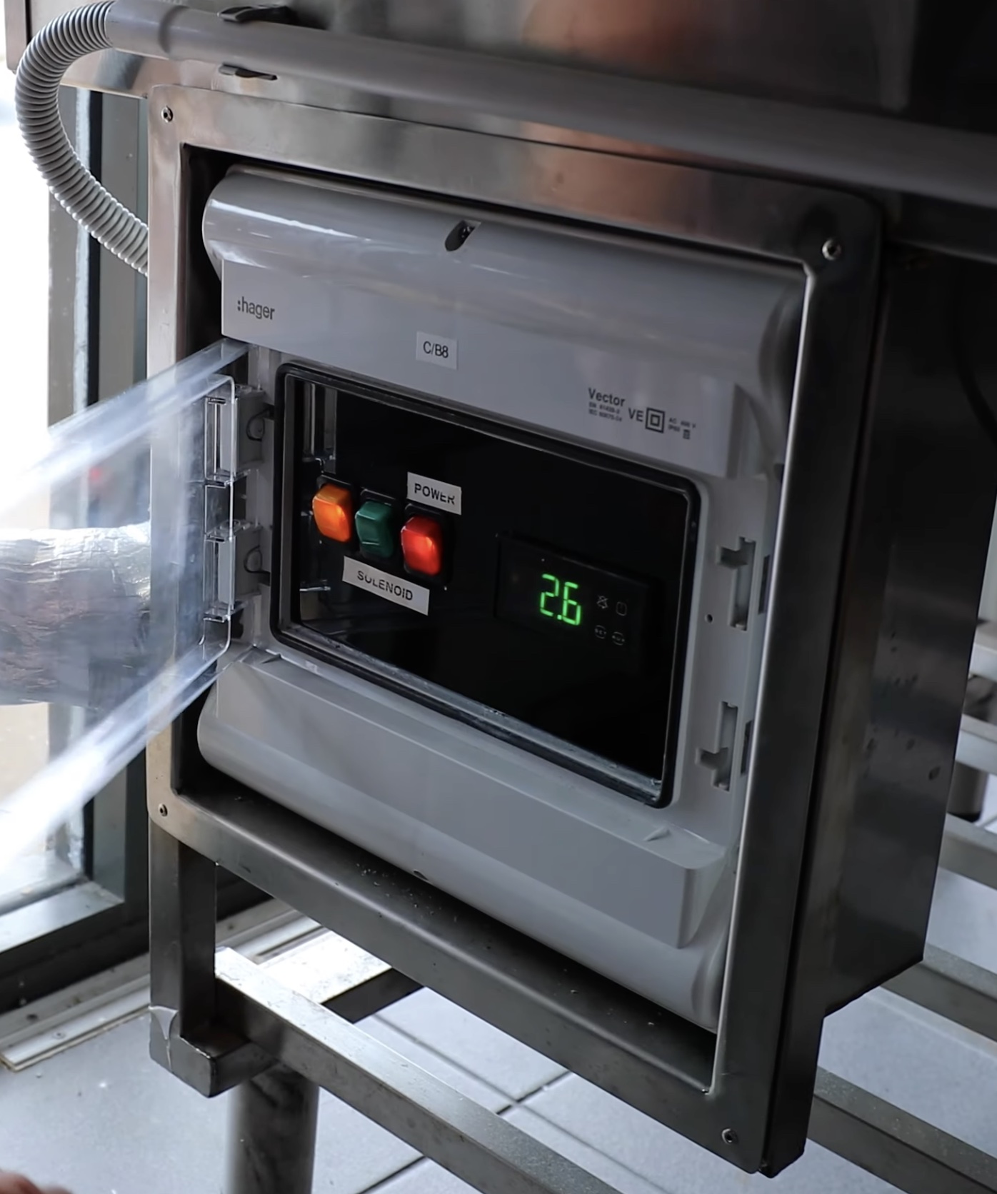 A refrigeration controller showing a 2.6°C reading inside a stainless steel control panel