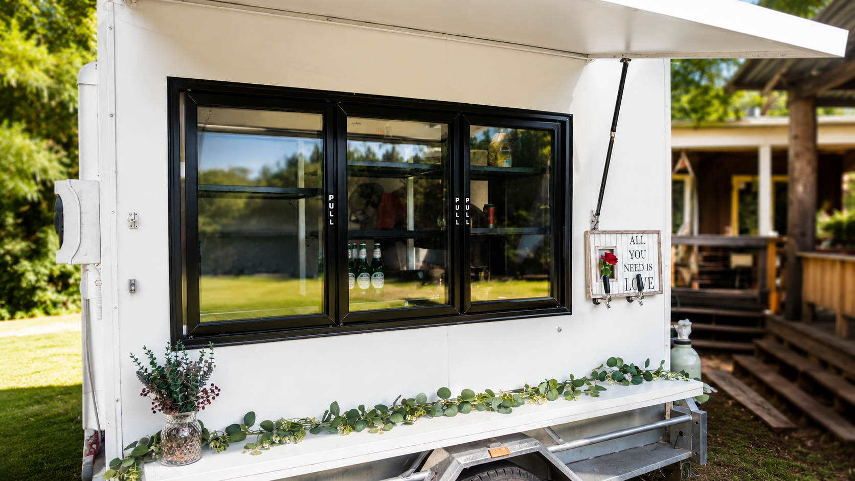 The SETPOINT party coldroom servery window styled for an event with eucalyptus garland and chilled drinks